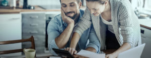 Couple looking at calculator and paperwork